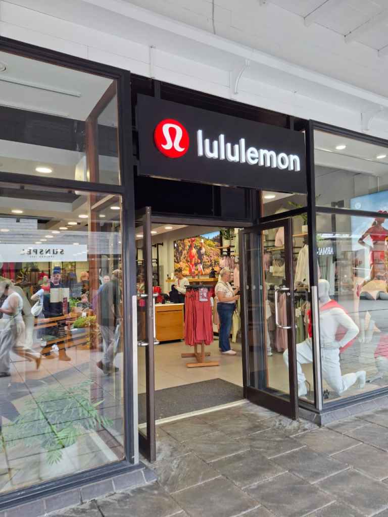 A lululemon storefront with people inside at Cheshire Oaks outlet village.