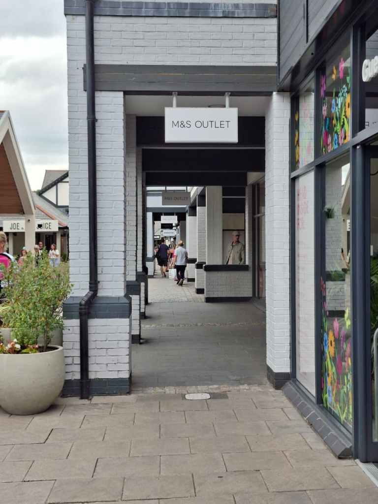 A view down the storefronts at Cheshire Oaks outlet village.