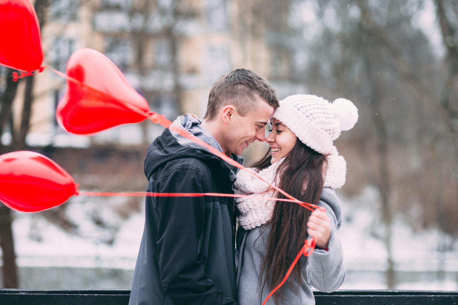 happy friends with arms outstretched in city during winter